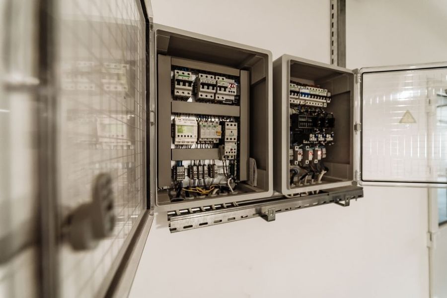 Open electrical control panels with various components mounted inside.