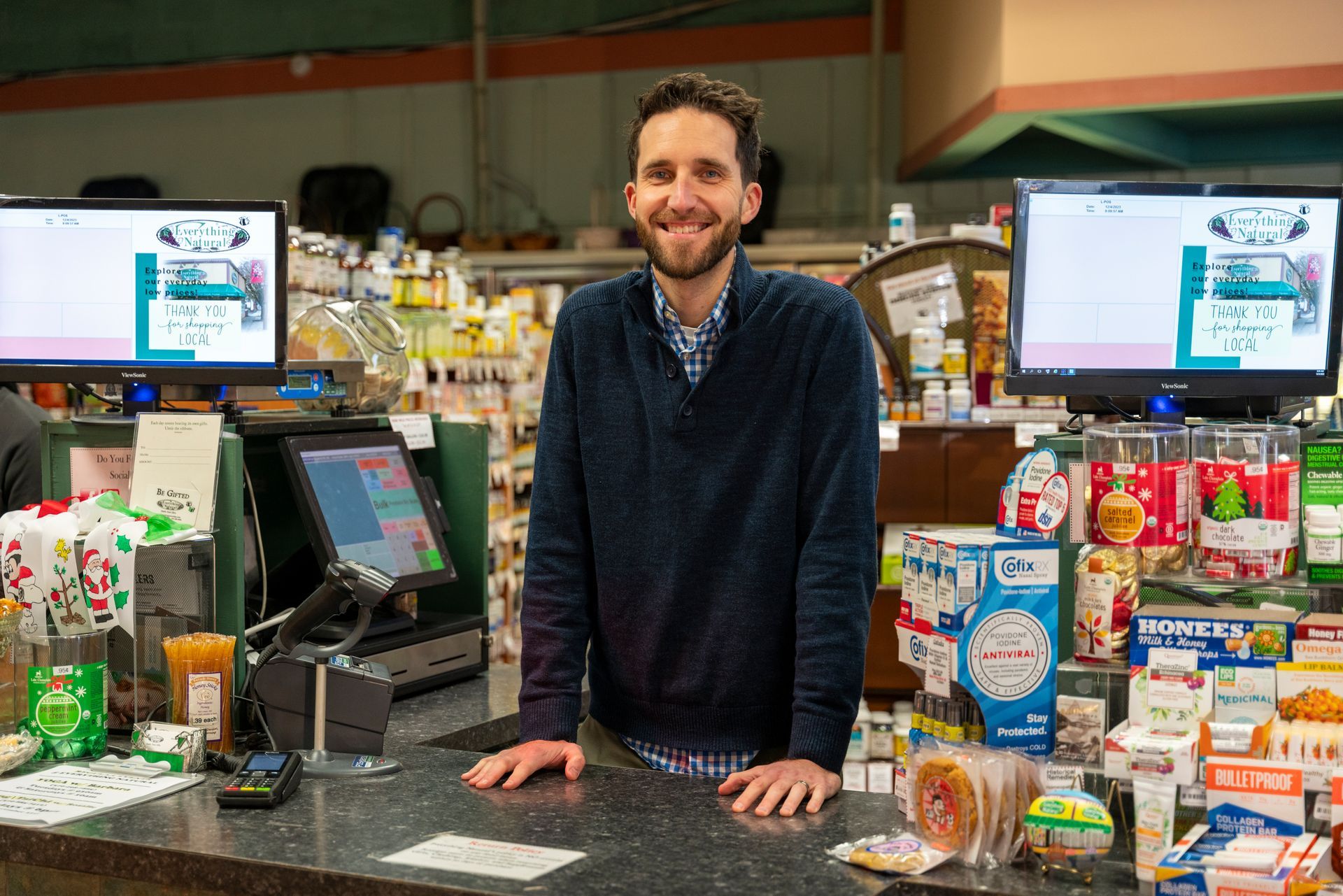 a man is standing behind a counter in a grocery store .