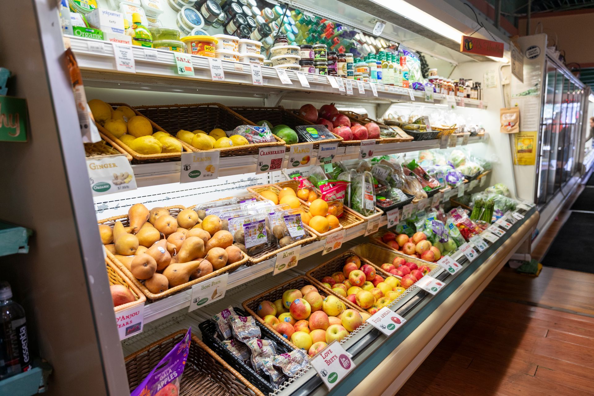 A grocery store refrigerator filled with fruits and vegetables.