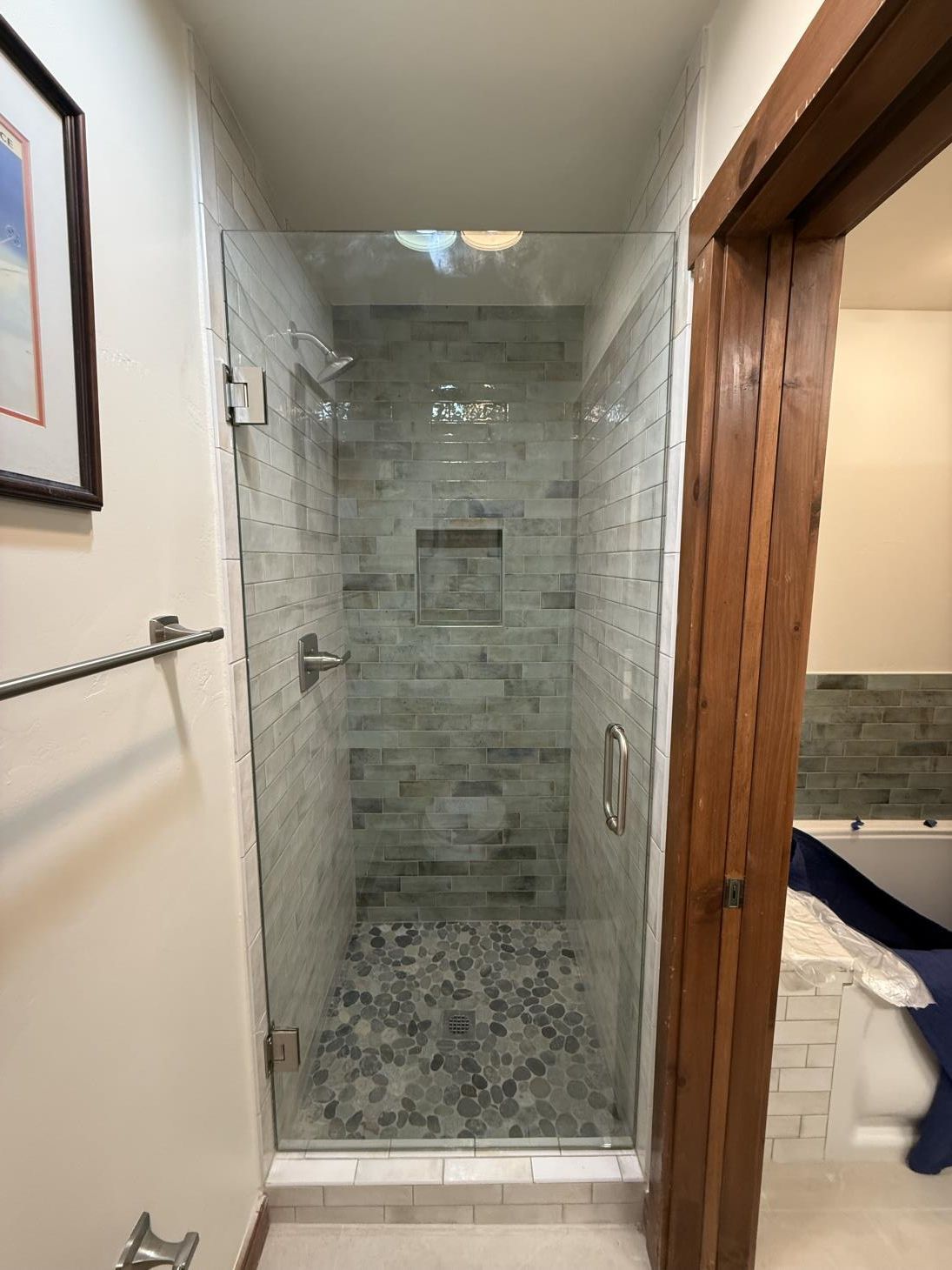 a man is installing tiles on a wall in a bathroom .