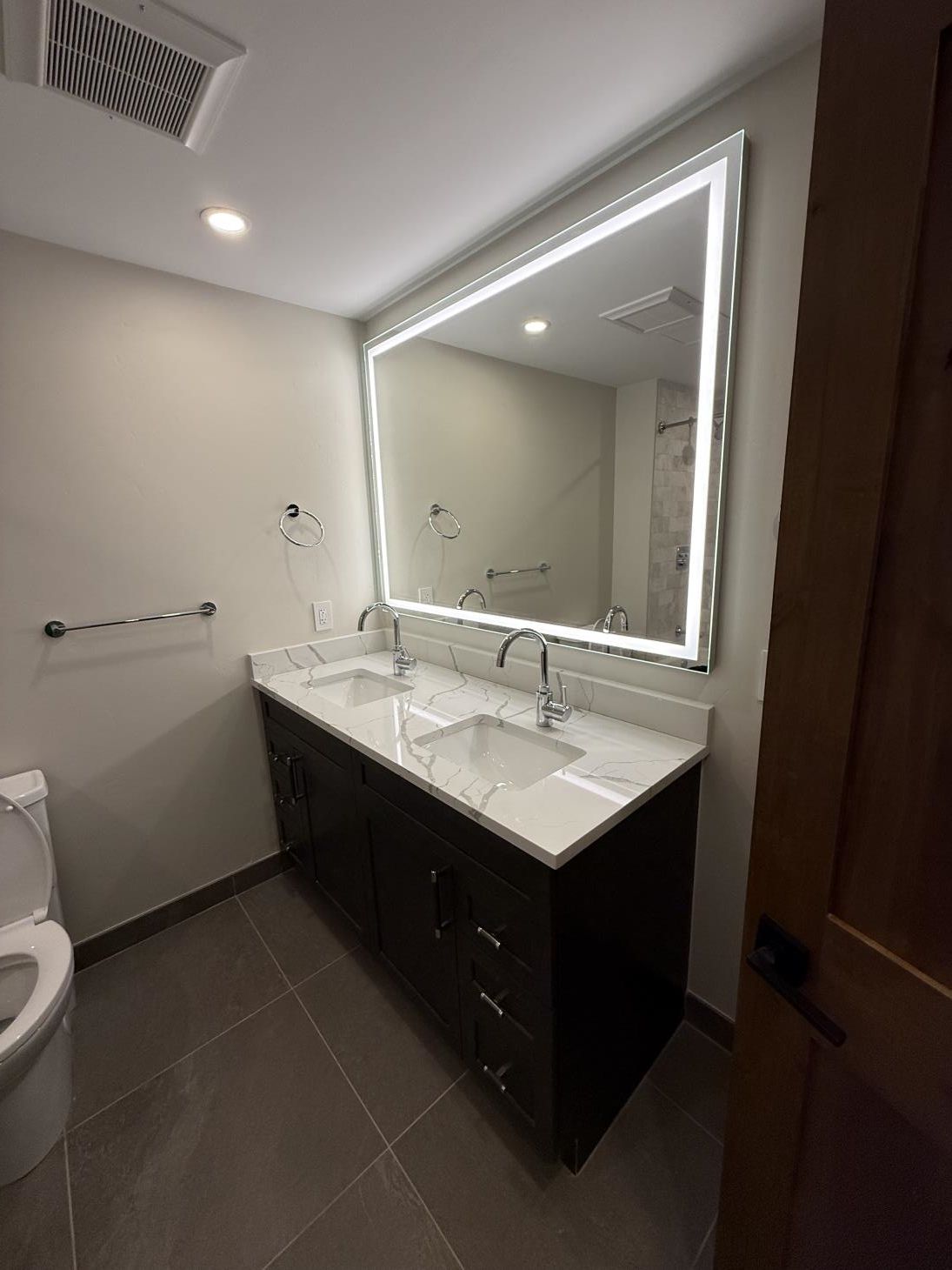 a man is installing tiles on a wall in a bathroom .