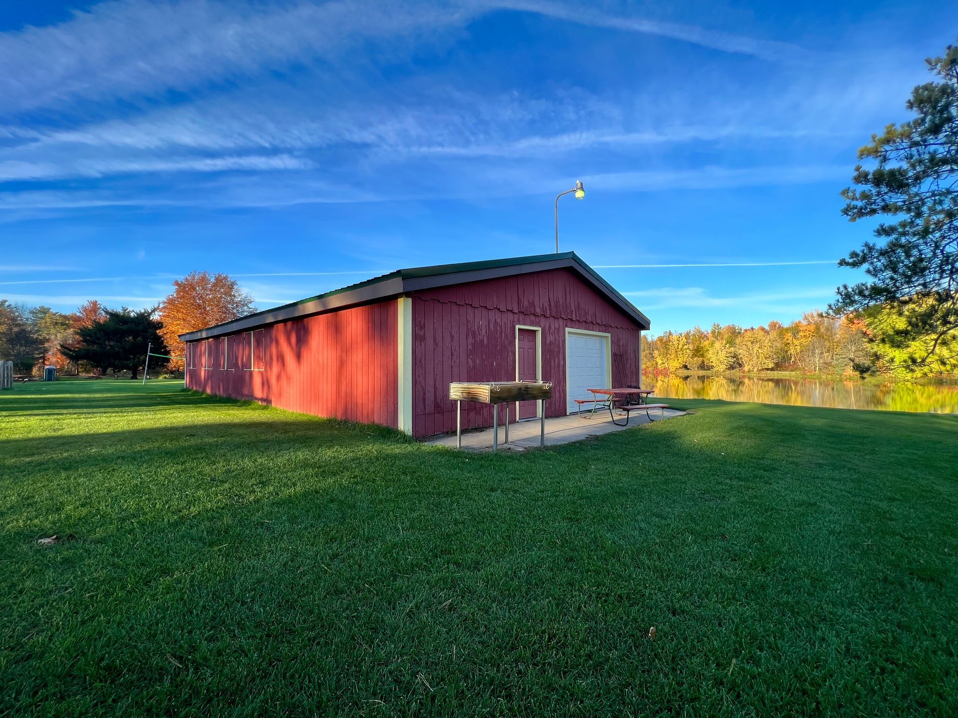A red barn is sitting in the middle of a lush green field.