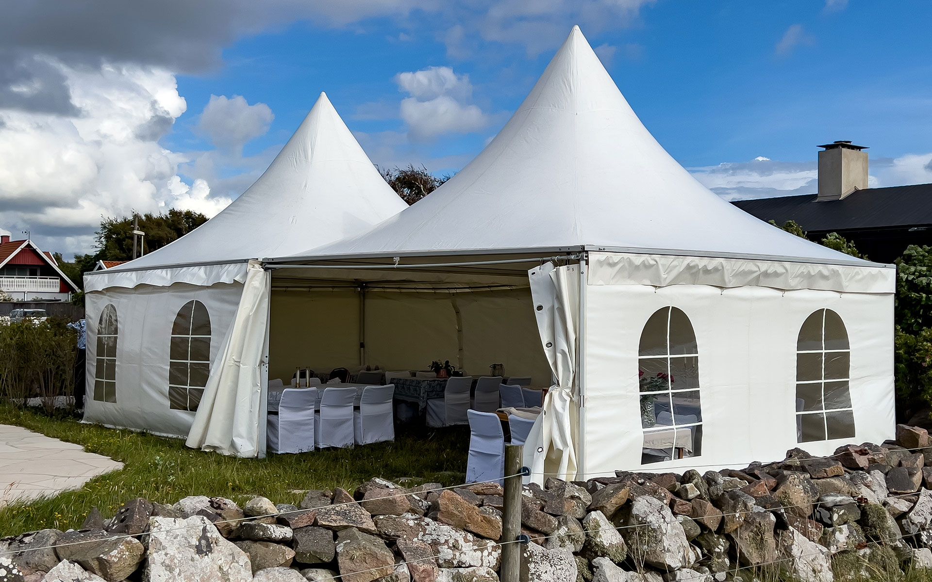 A white tent with tables and chairs inside of it