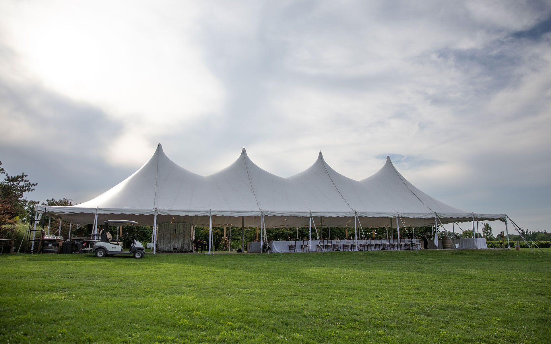 A large white tent is sitting in the middle of a grassy field.