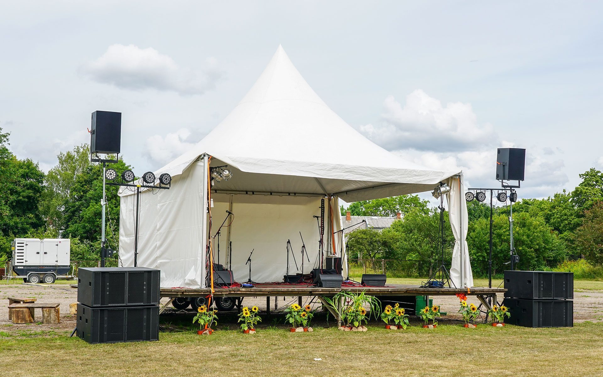 A large white tent is sitting in the middle of a grassy field.