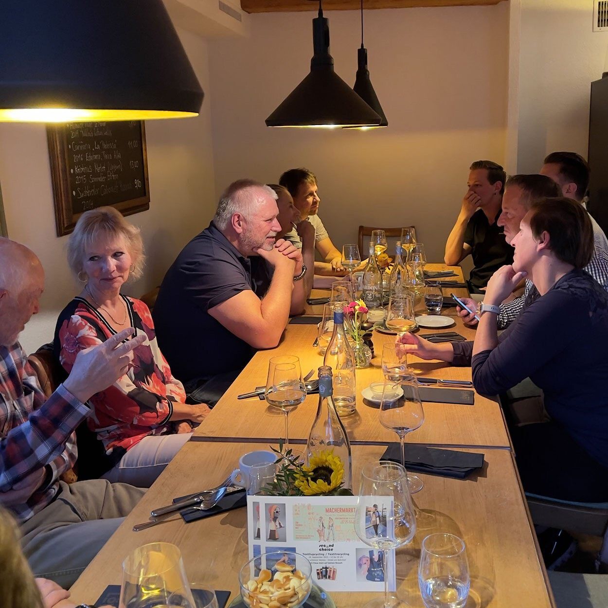 Eine Gruppe von Menschen sitzt um einen langen Tisch herum