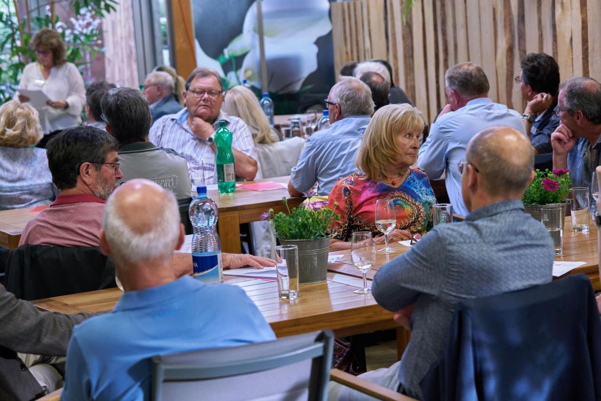 Eine Gruppe von Leuten sitzt an Tischen in einem Restaurant.