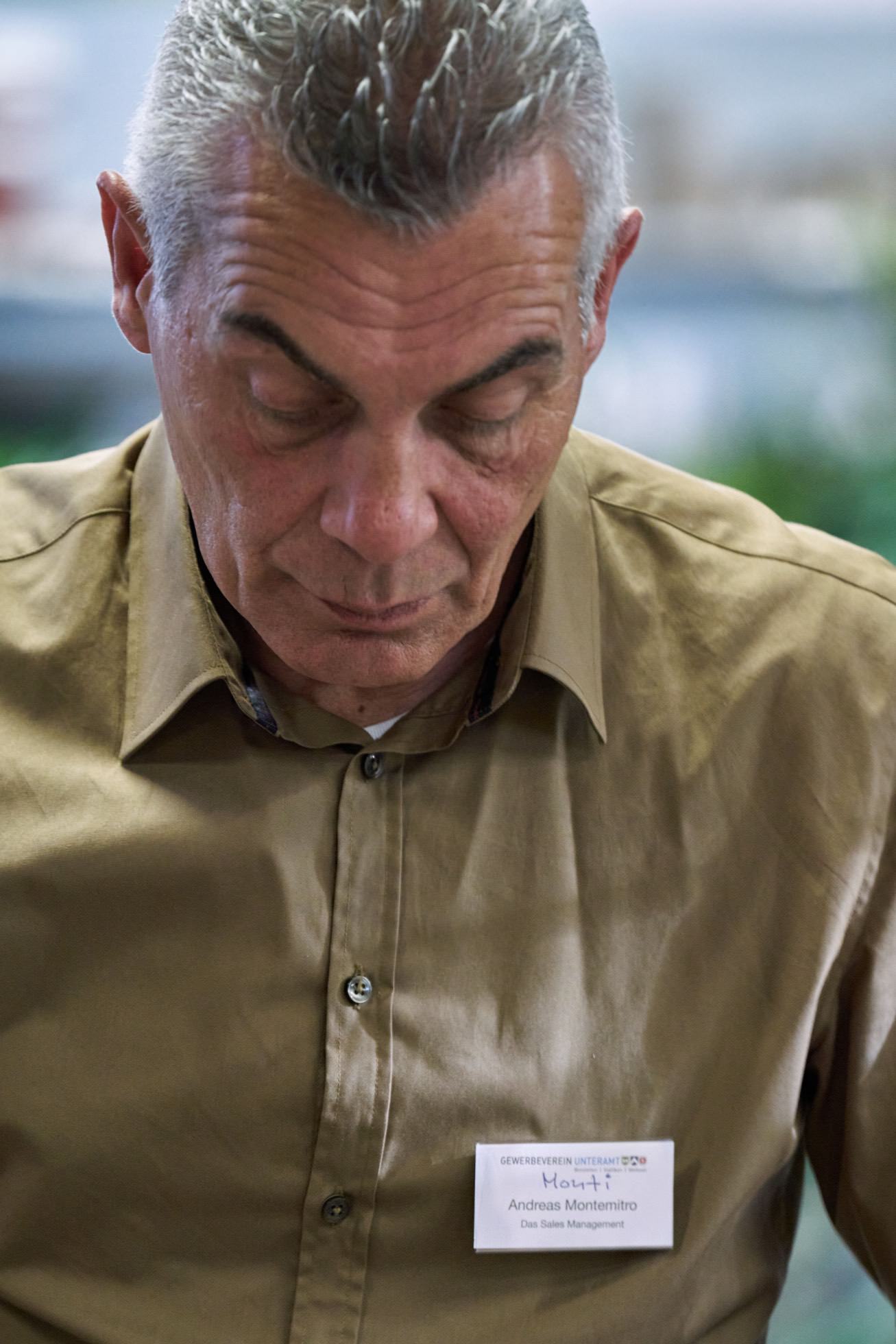 Ein Mann mit einem Namensschild auf seinem Hemd schaut nach unten