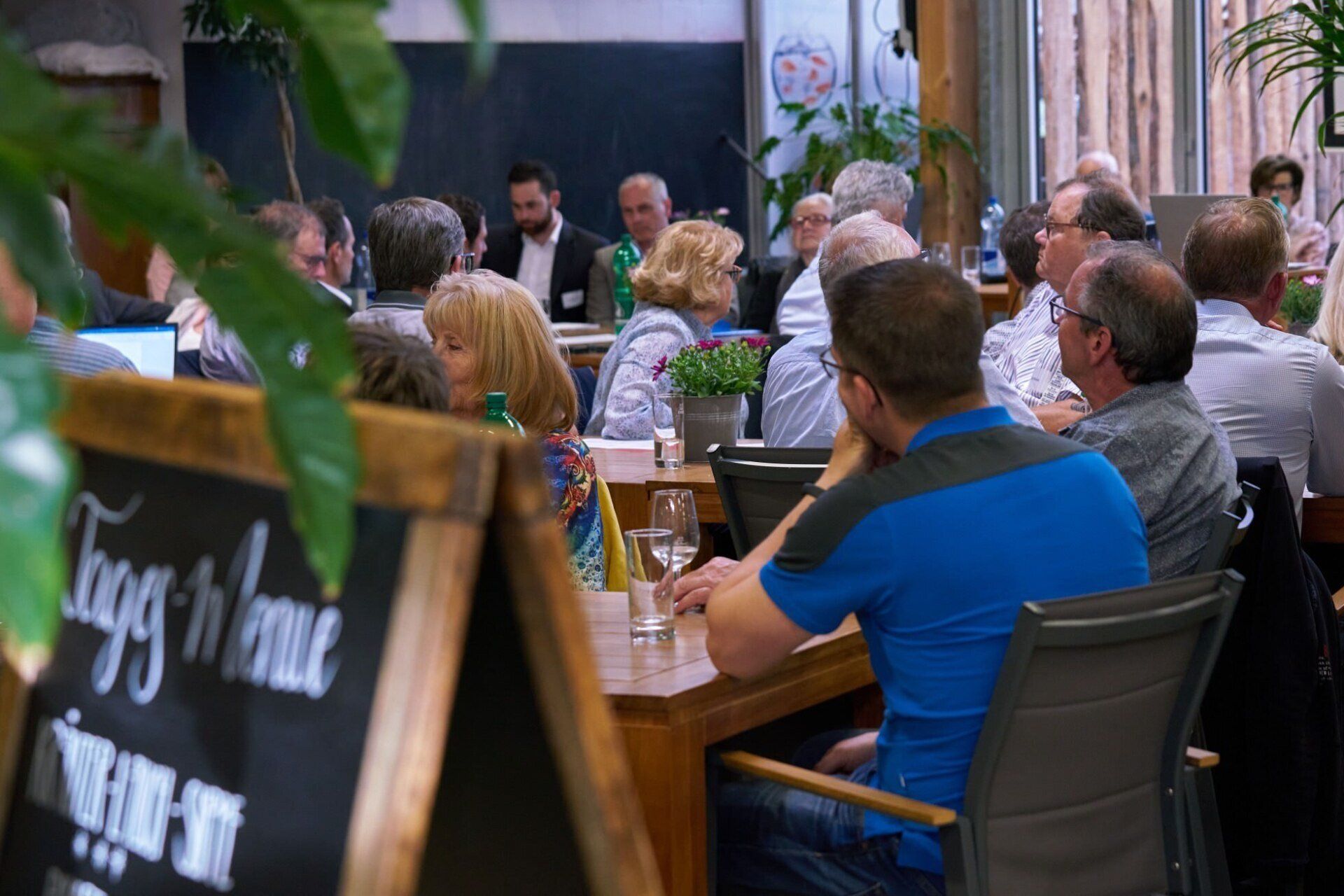 Eine Gruppe von Leuten sitzt an Tischen in einem Restaurant.