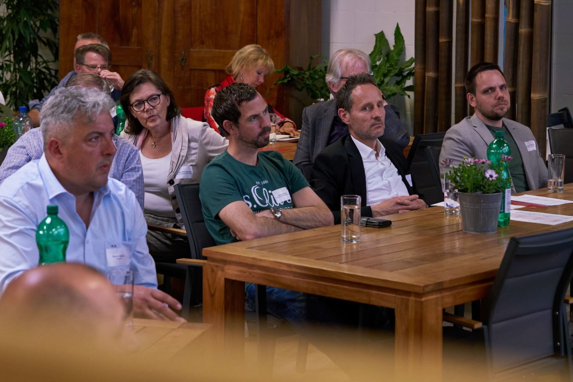 Eine Gruppe von Leuten sitzt in einem Raum an Tischen.
