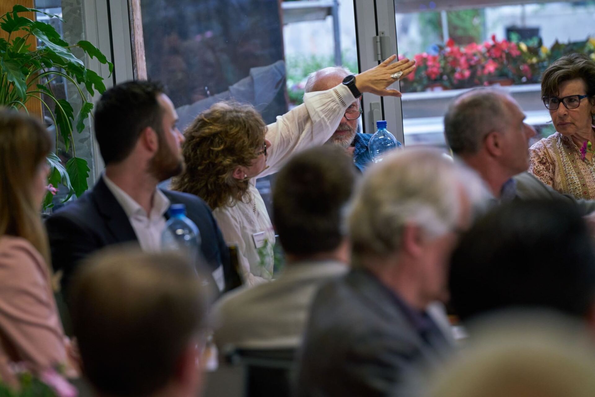 Eine Gruppe von Leuten sitzt in einem Raum an einem Tisch.