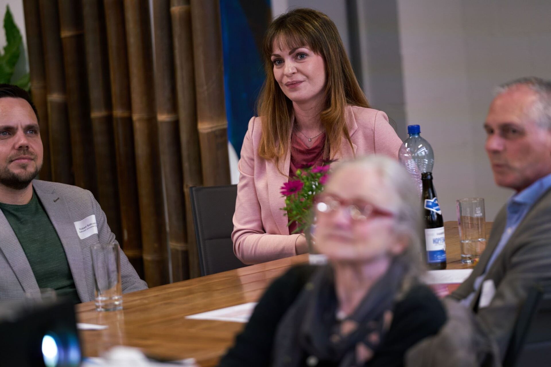Eine Gruppe von Menschen sitzt an einem Tisch in einem Konferenzraum.