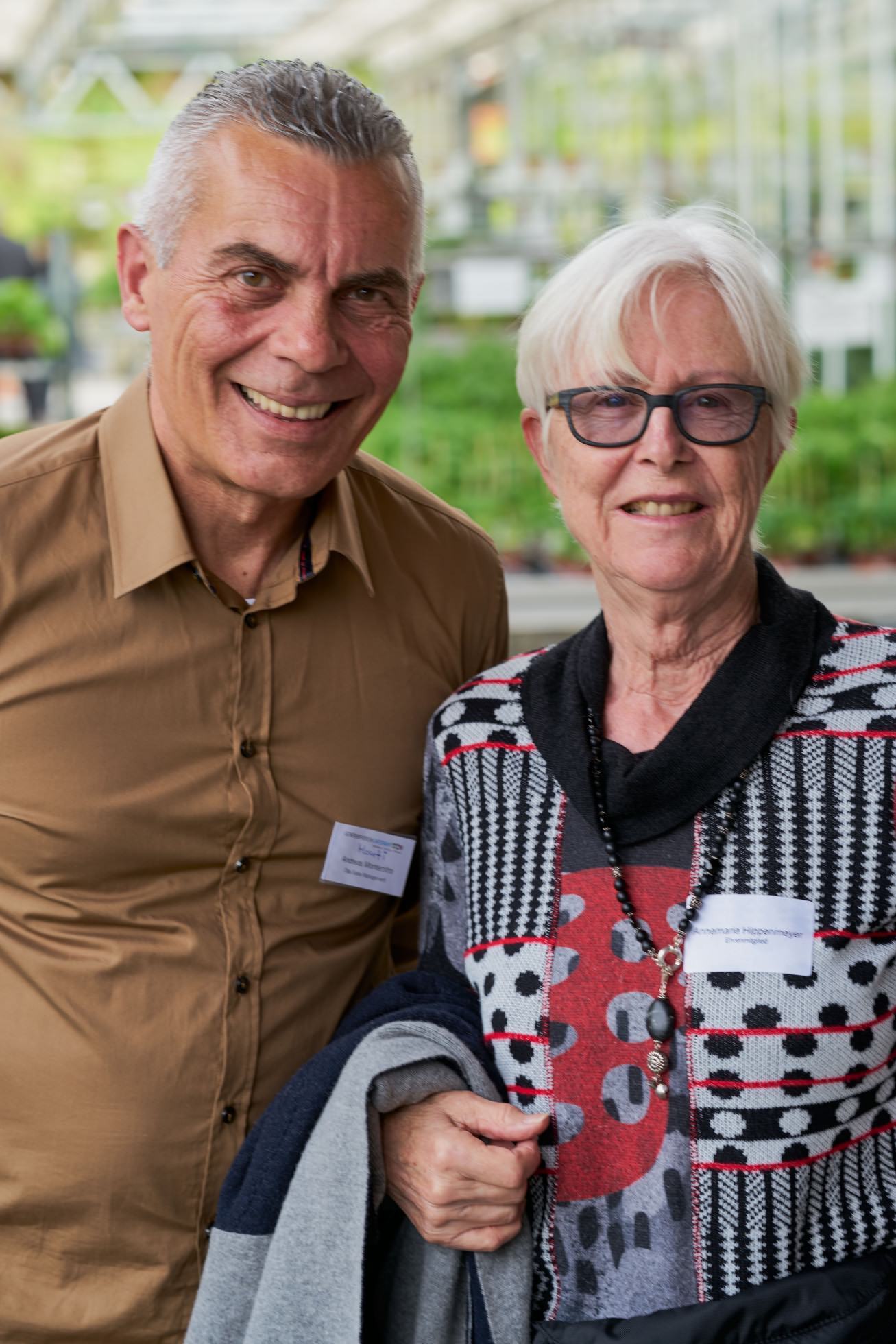Ein Mann und eine Frau posieren in einem Gewächshaus für ein Foto.