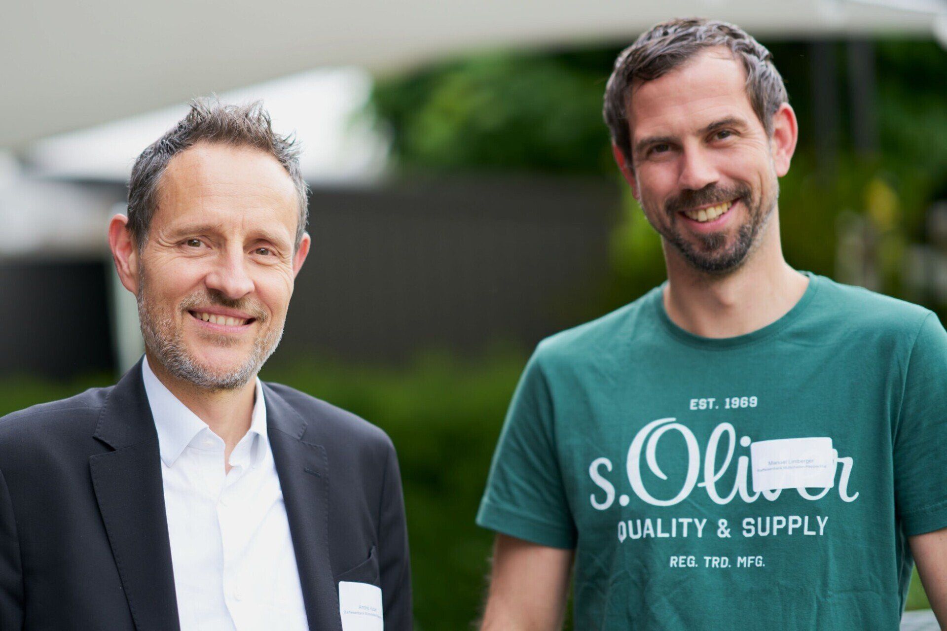 Zwei Männer stehen nebeneinander und einer von ihnen trägt ein S.Oliver-Shirt.