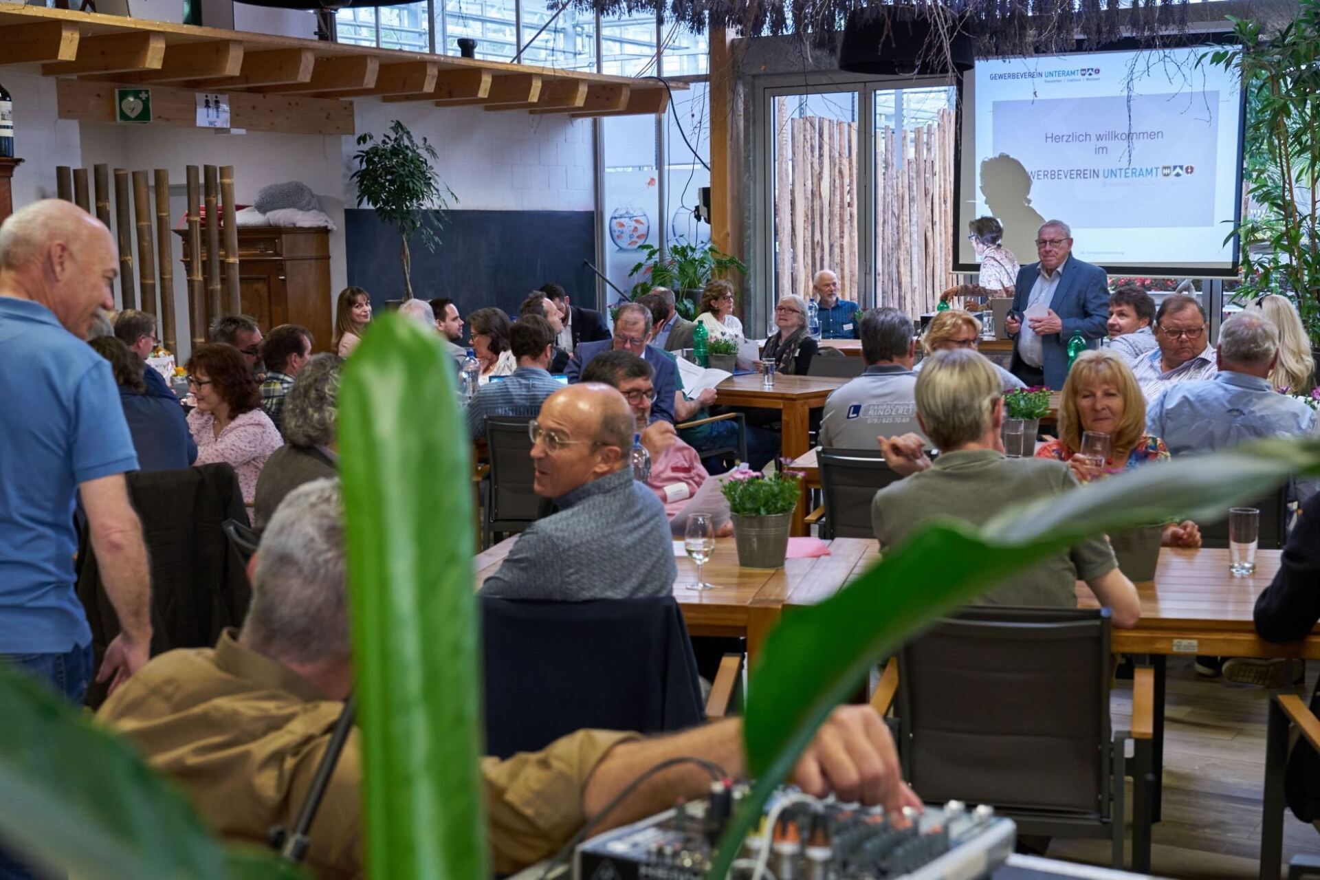 Eine Gruppe von Leuten sitzt an Tischen in einem Restaurant.