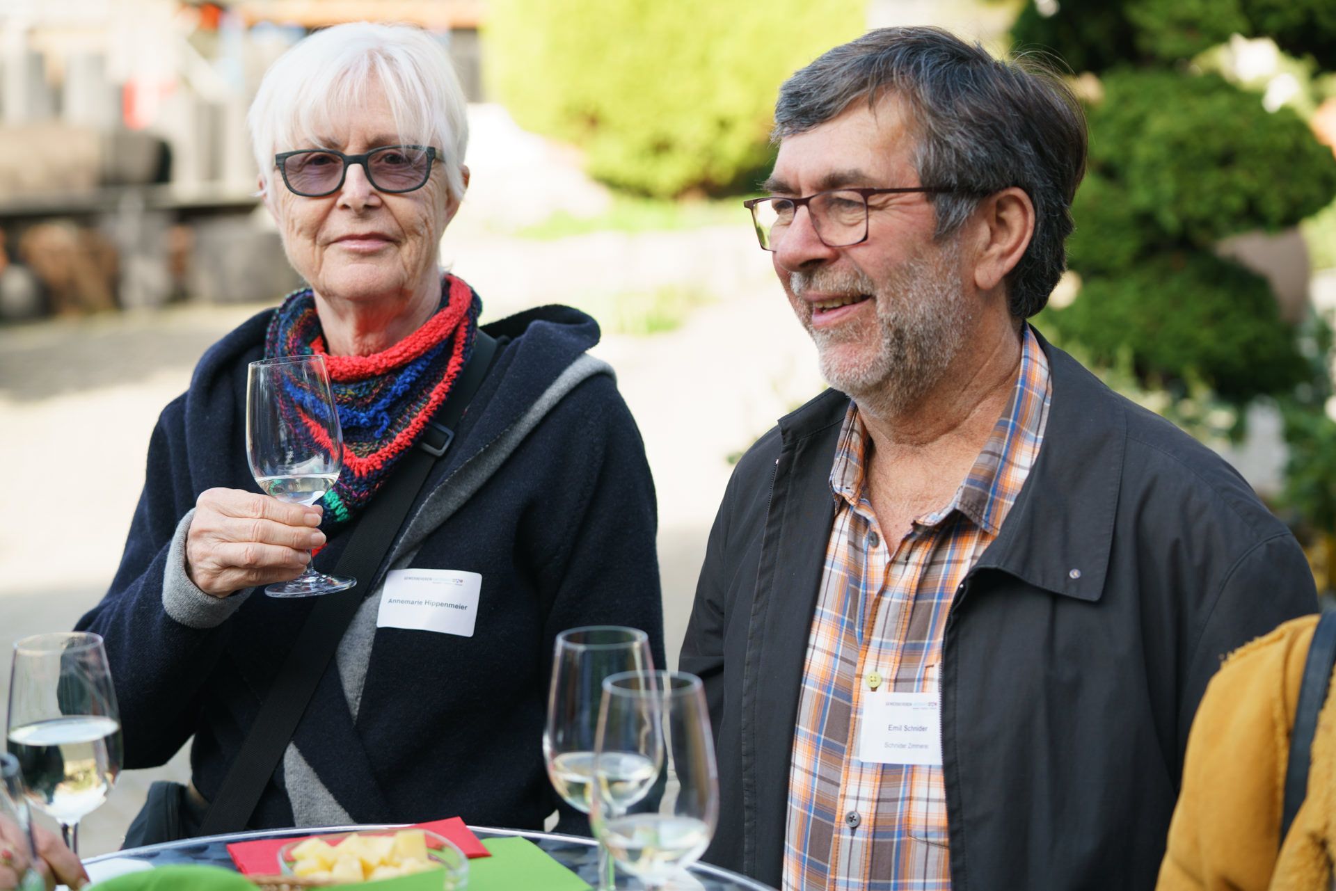 Ein Mann und eine Frau sitzen mit Weingläsern an einem Tisch.