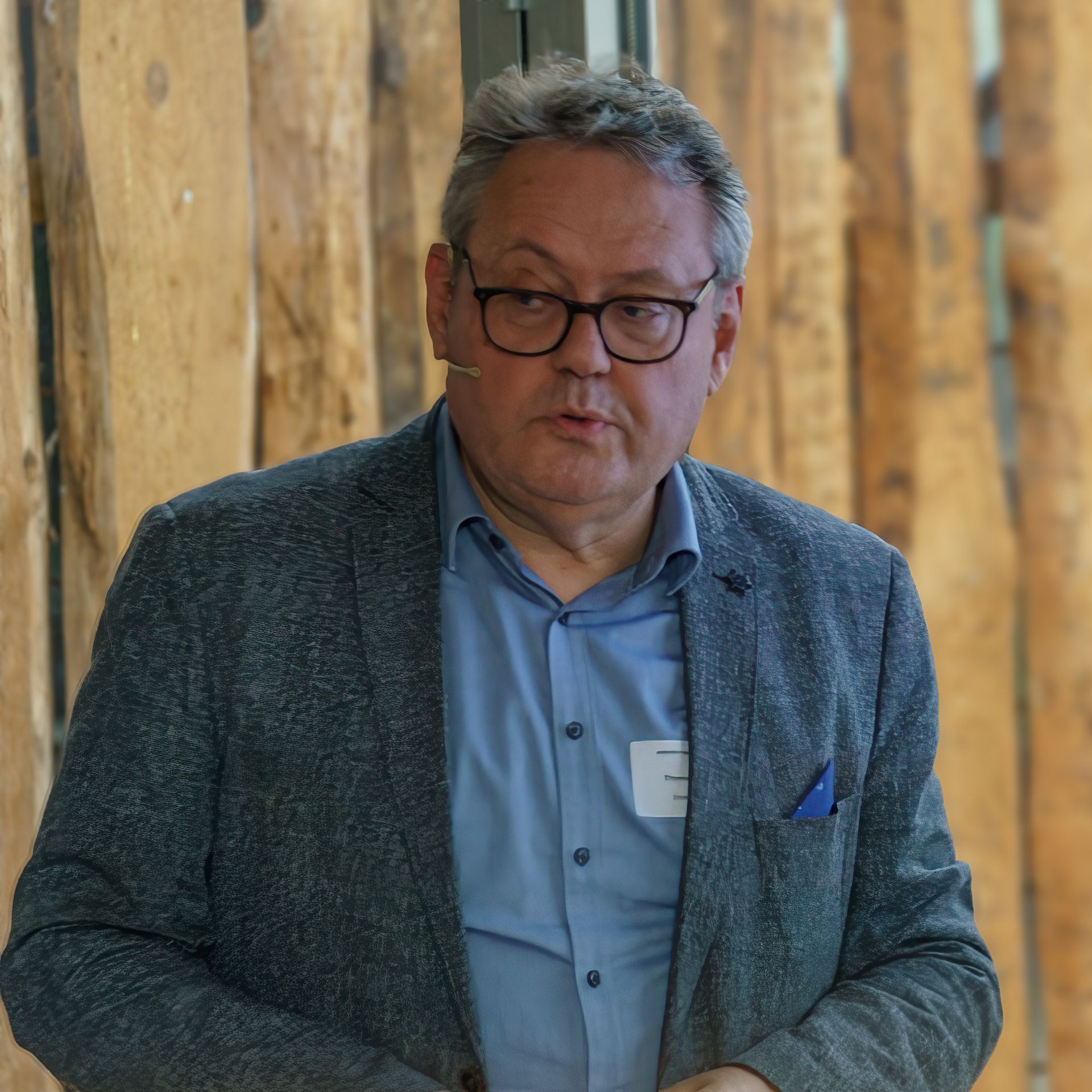 Ein Mann mit Brille und einem Namensschild mit dem Buchstaben E darauf