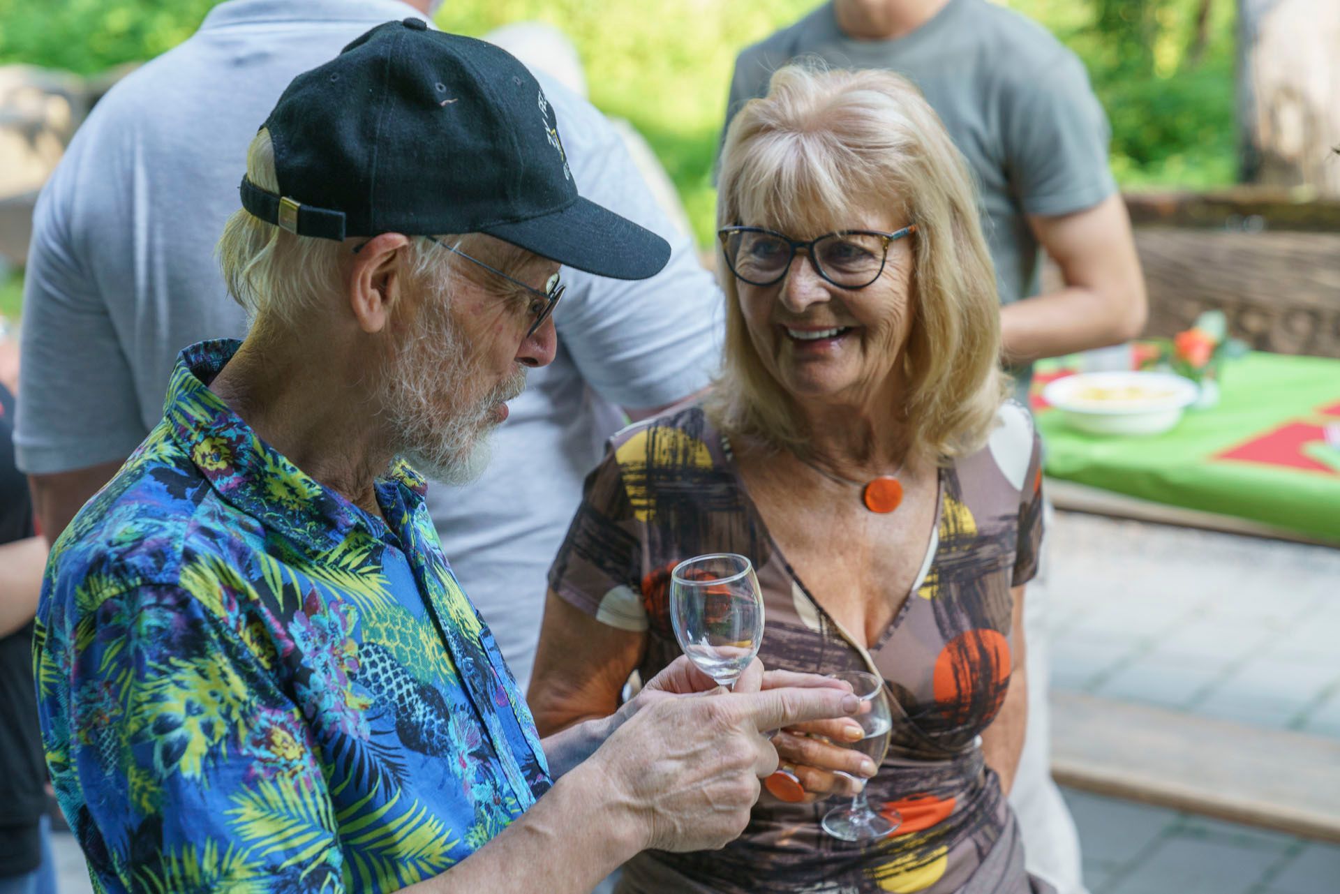 Ein Mann und eine Frau stehen nebeneinander und halten Weingläser.