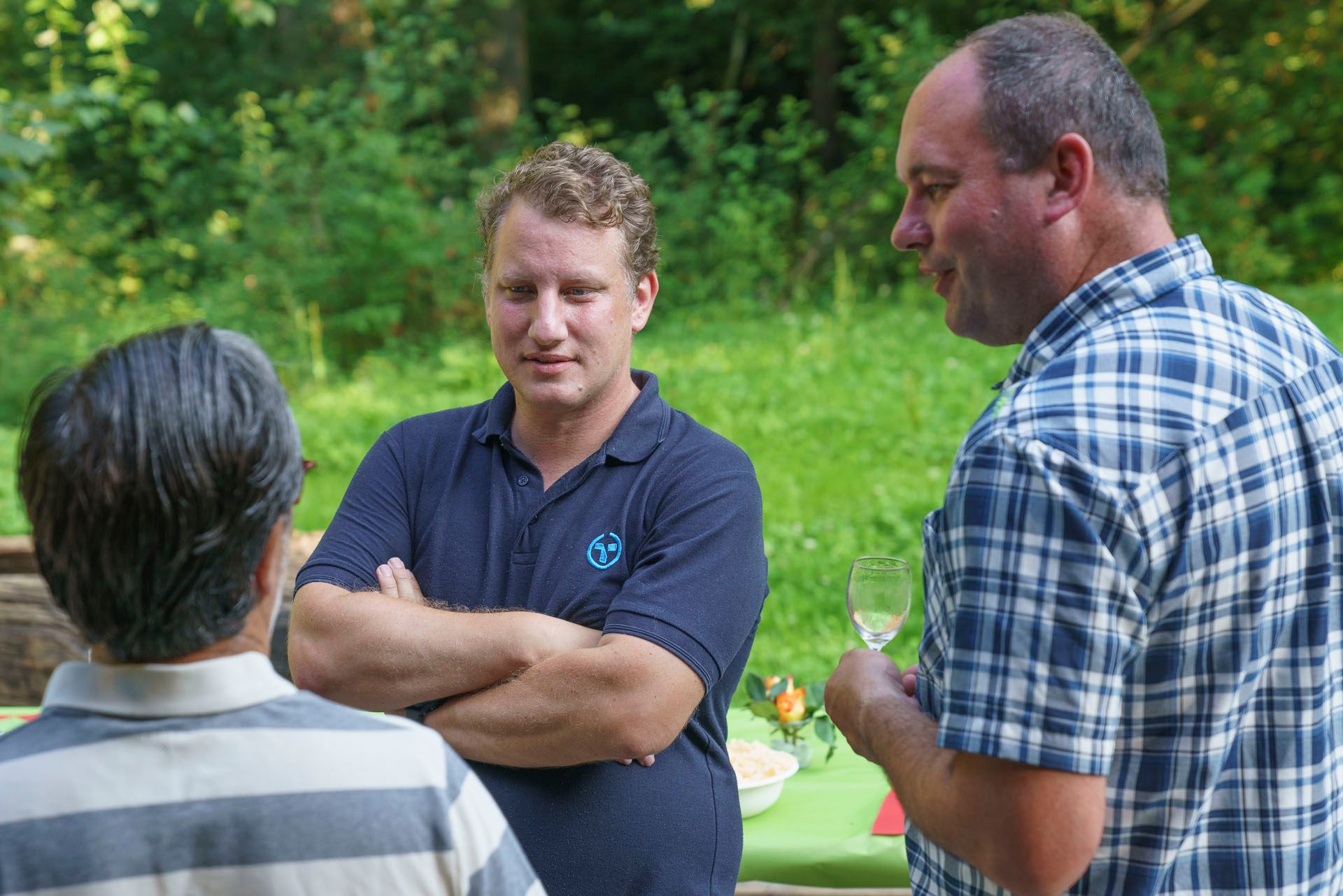 Drei Männer stehen nebeneinander und unterhalten sich.