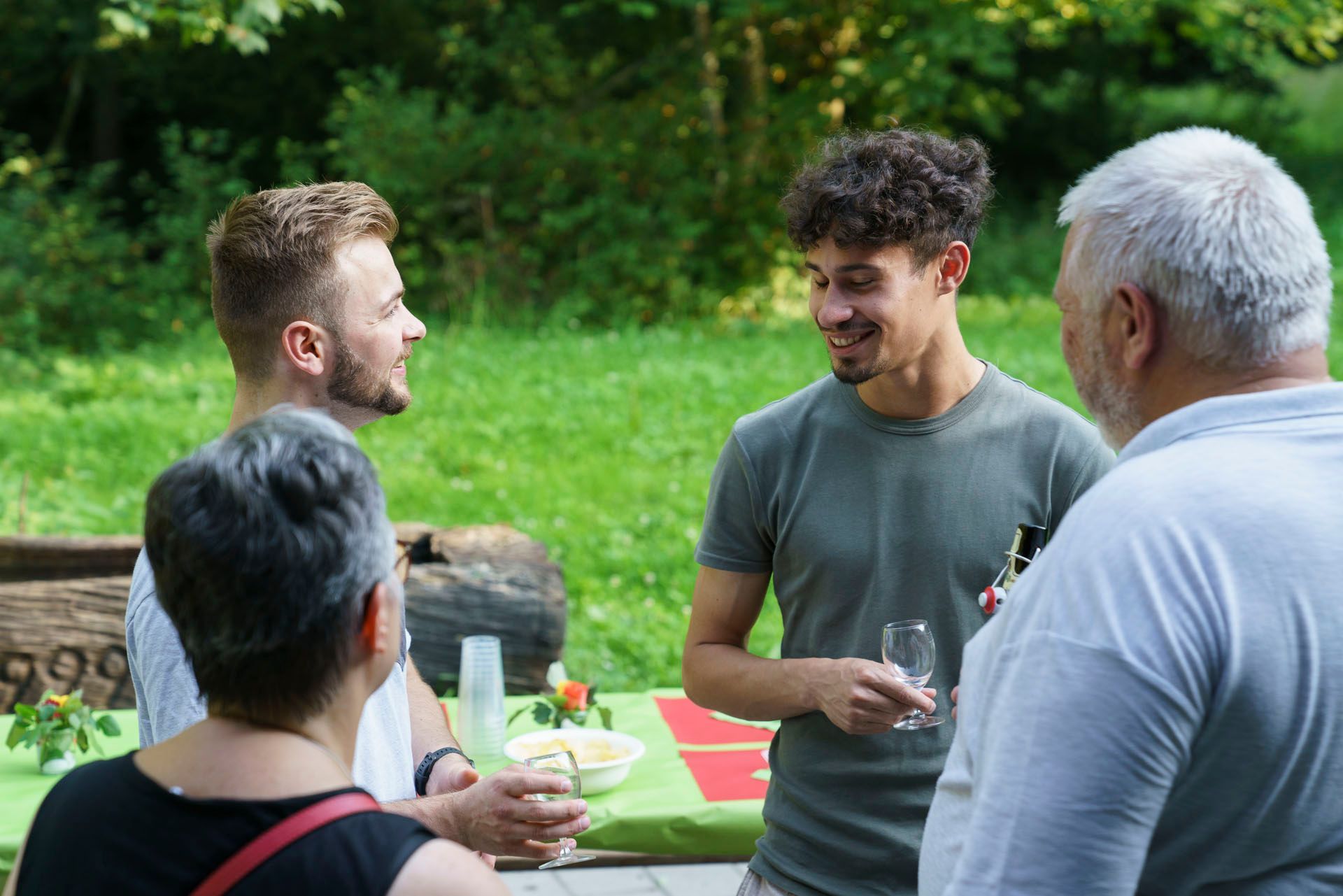 Eine Gruppe von Leuten steht um einen Tisch herum und unterhält sich miteinander.