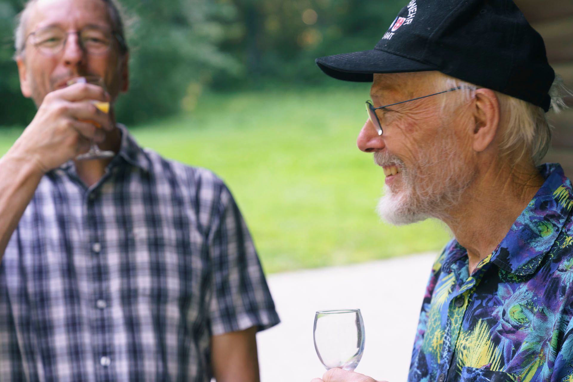 Zwei Männer stehen nebeneinander und trinken Wein