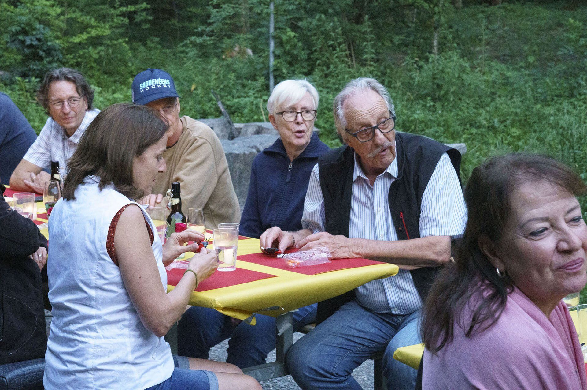Eine Gruppe von Leuten sitzt an einem Tisch und isst und trinkt.