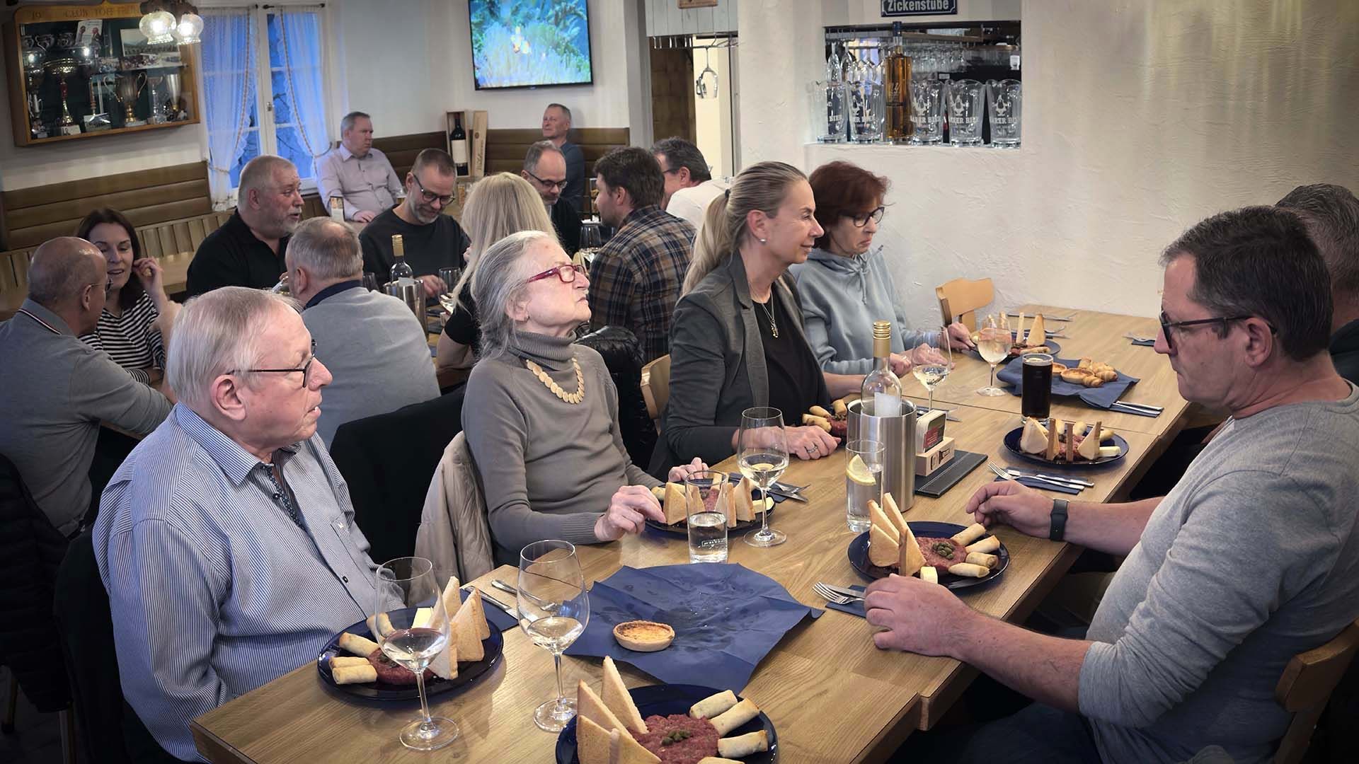 Eine Gruppe Leute sitzt an einem Tisch und isst.