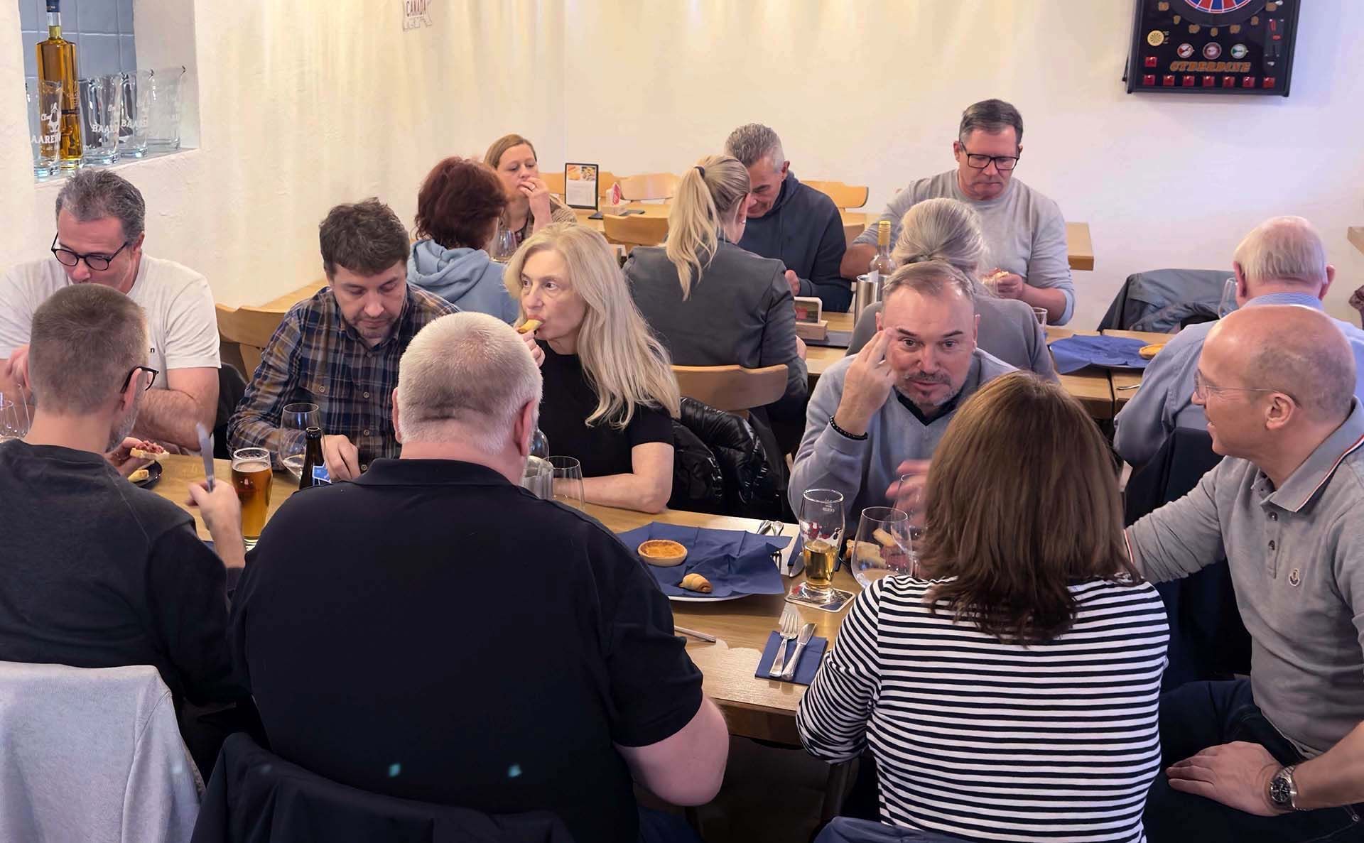 Eine Gruppe von Leuten sitzt an Tischen in einem Restaurant.