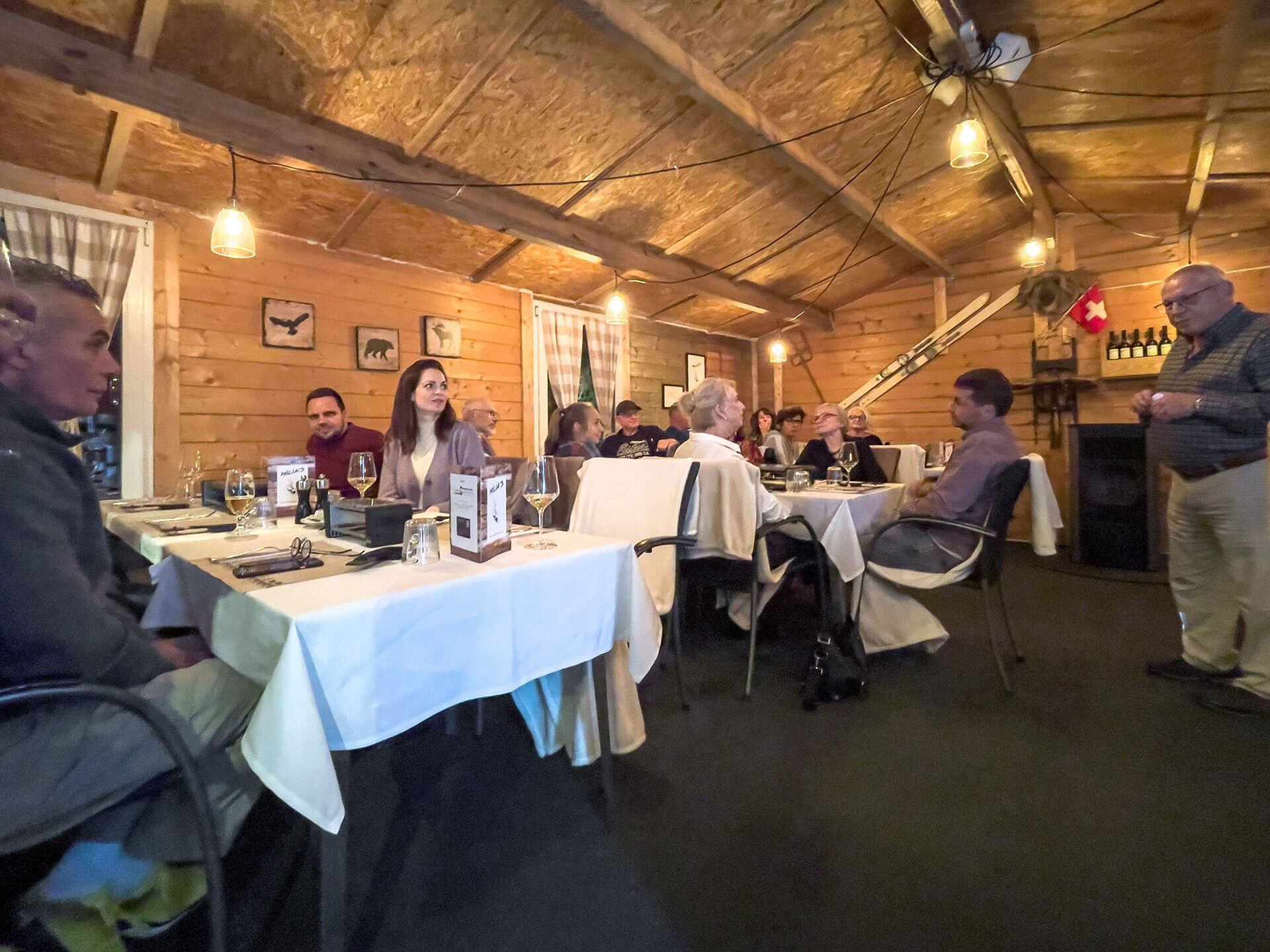 Eine Gruppe von Leuten sitzt an Tischen in einem Restaurant.