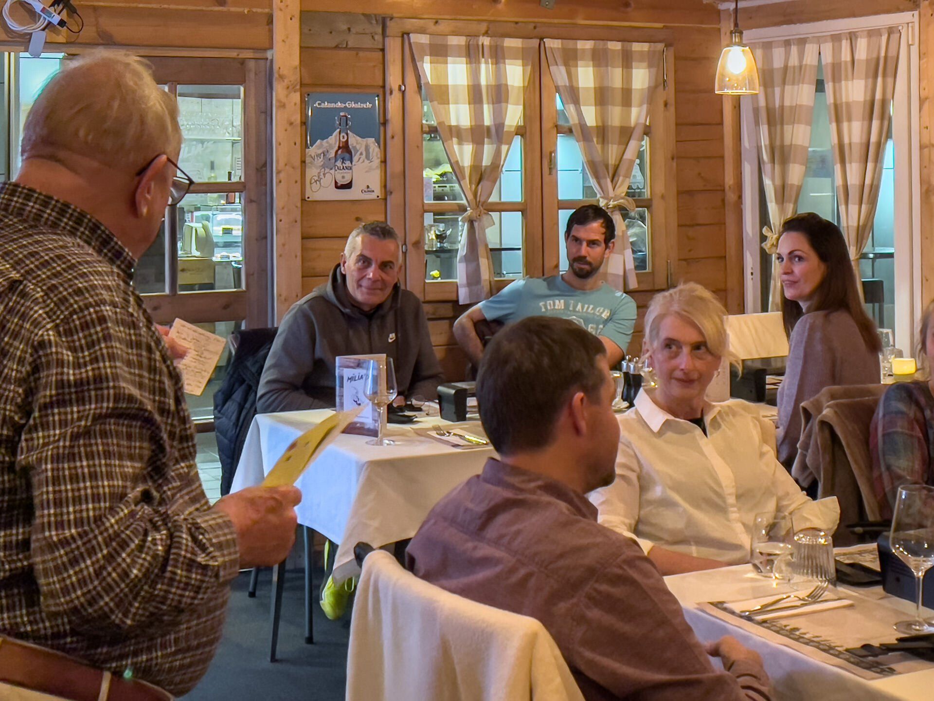 Eine Gruppe von Leuten sitzt an Tischen in einem Restaurant.