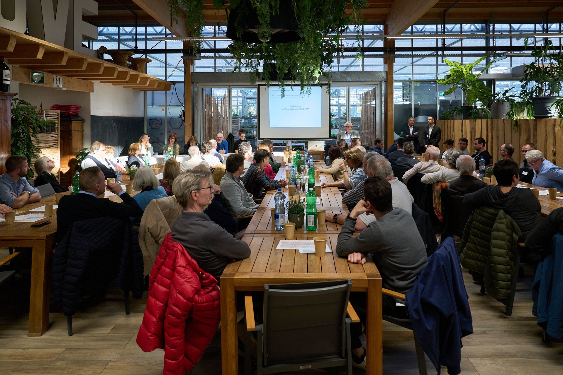 Eine große Gruppe von Menschen sitzt an Tischen in einem Restaurant.