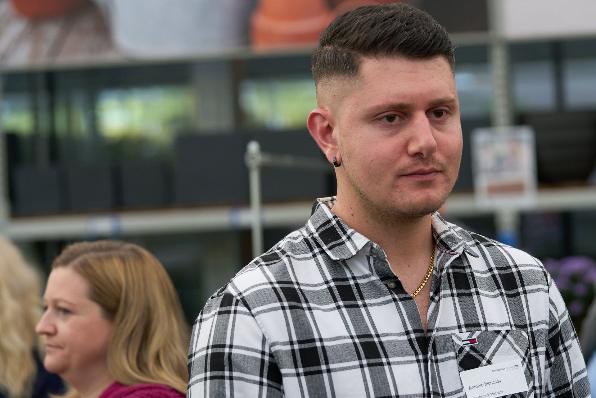 Ein Mann im karierten Hemd steht vor einer Frau.