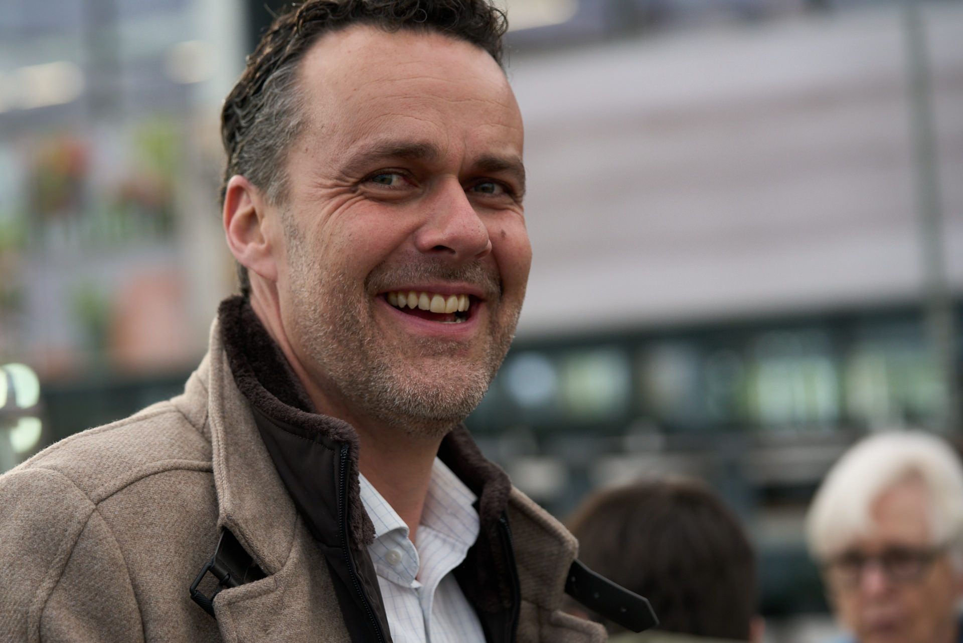 Ein Mann mit Bart lächelt und schaut in die Kamera.