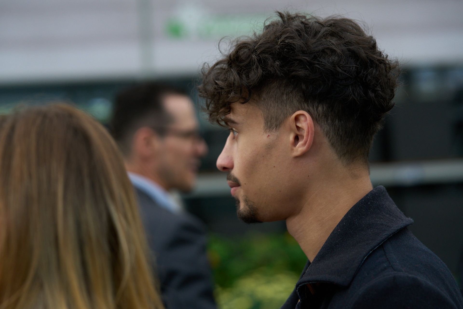 Ein Mann mit lockigem Haar und Bart spricht mit einer Frau.