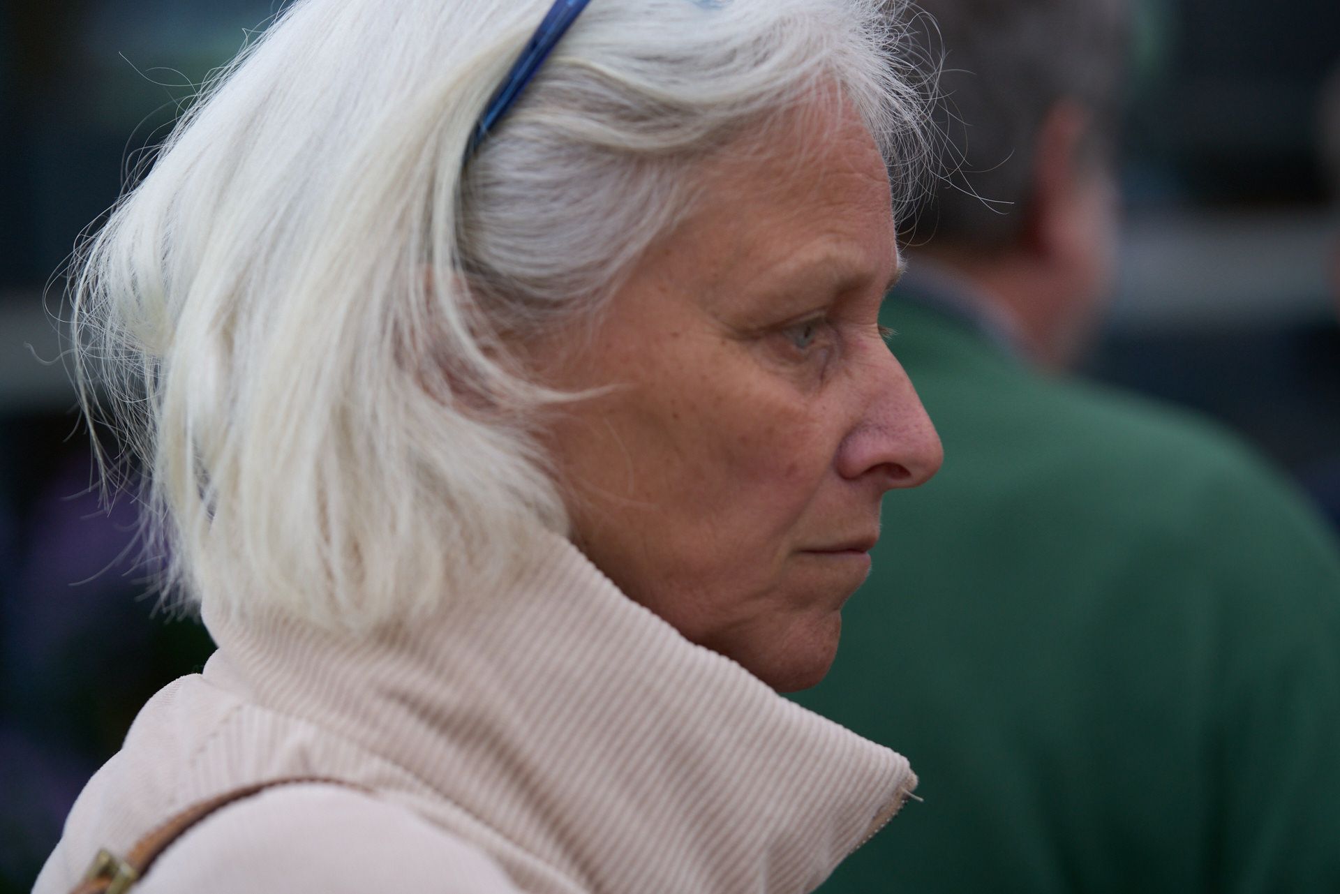 Eine Frau mit weißem Haar trägt ein Stirnband.