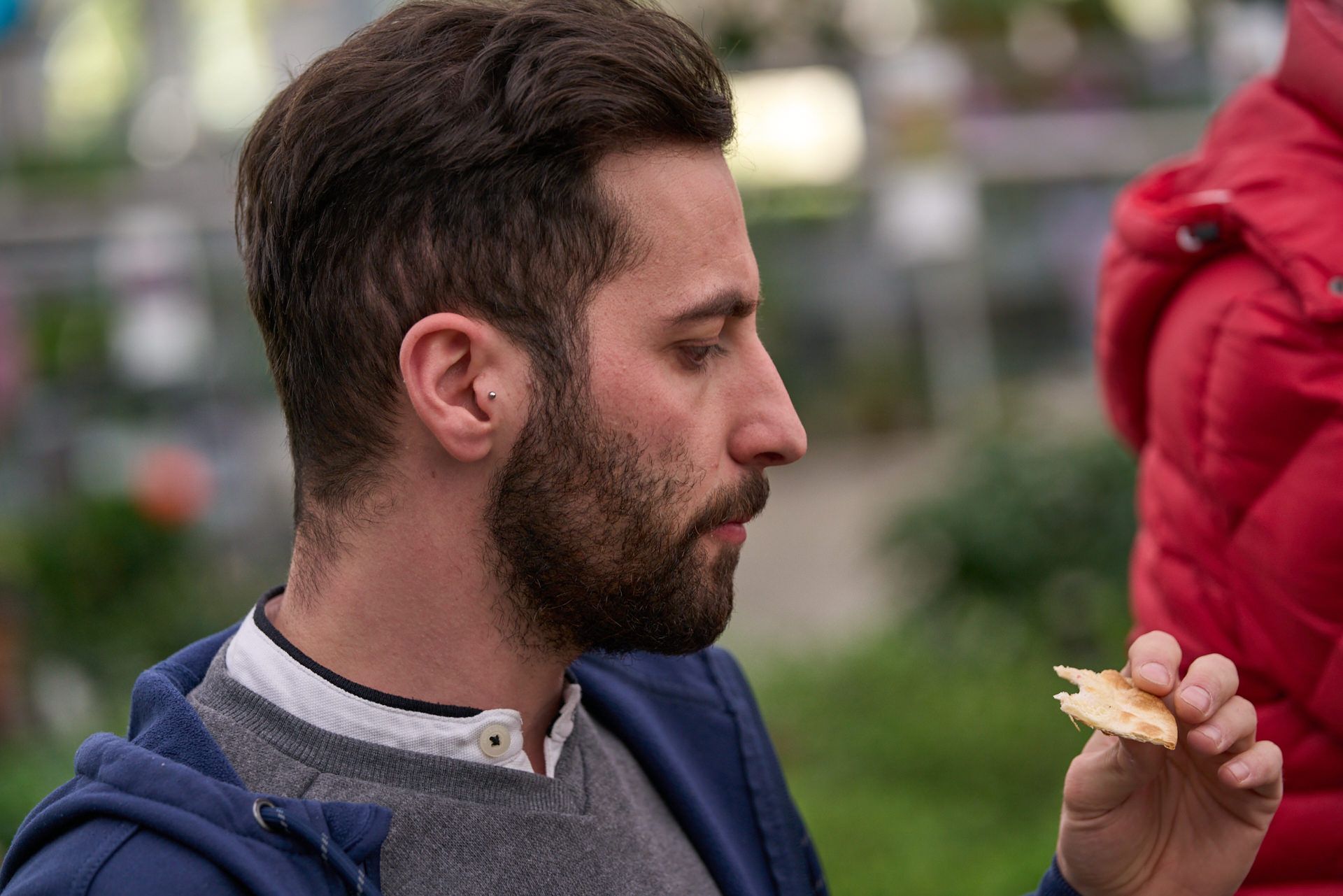 Ein Mann mit Bart isst ein Stück Essen.