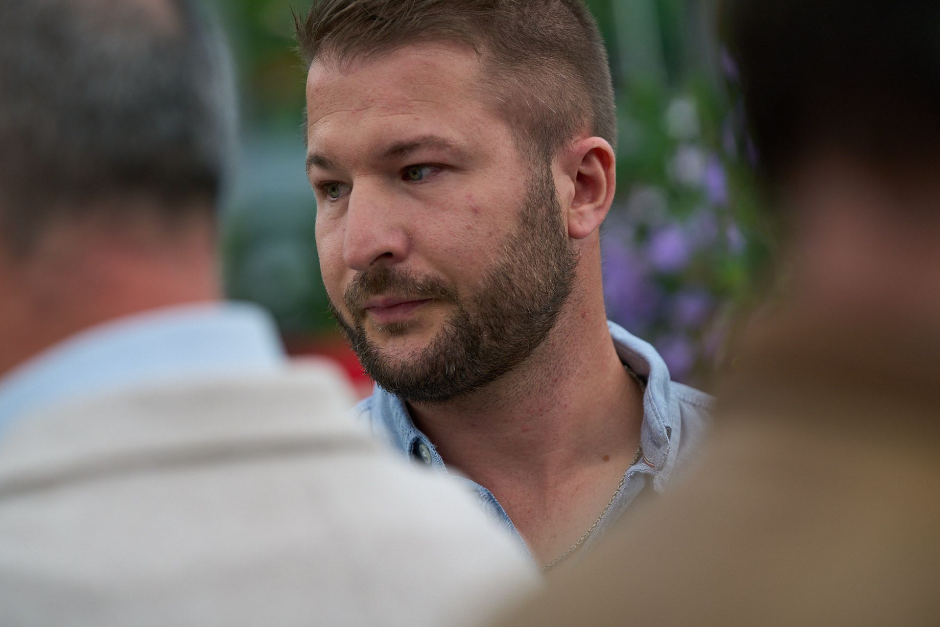 Ein Mann mit Bart spricht mit einem anderen Mann.