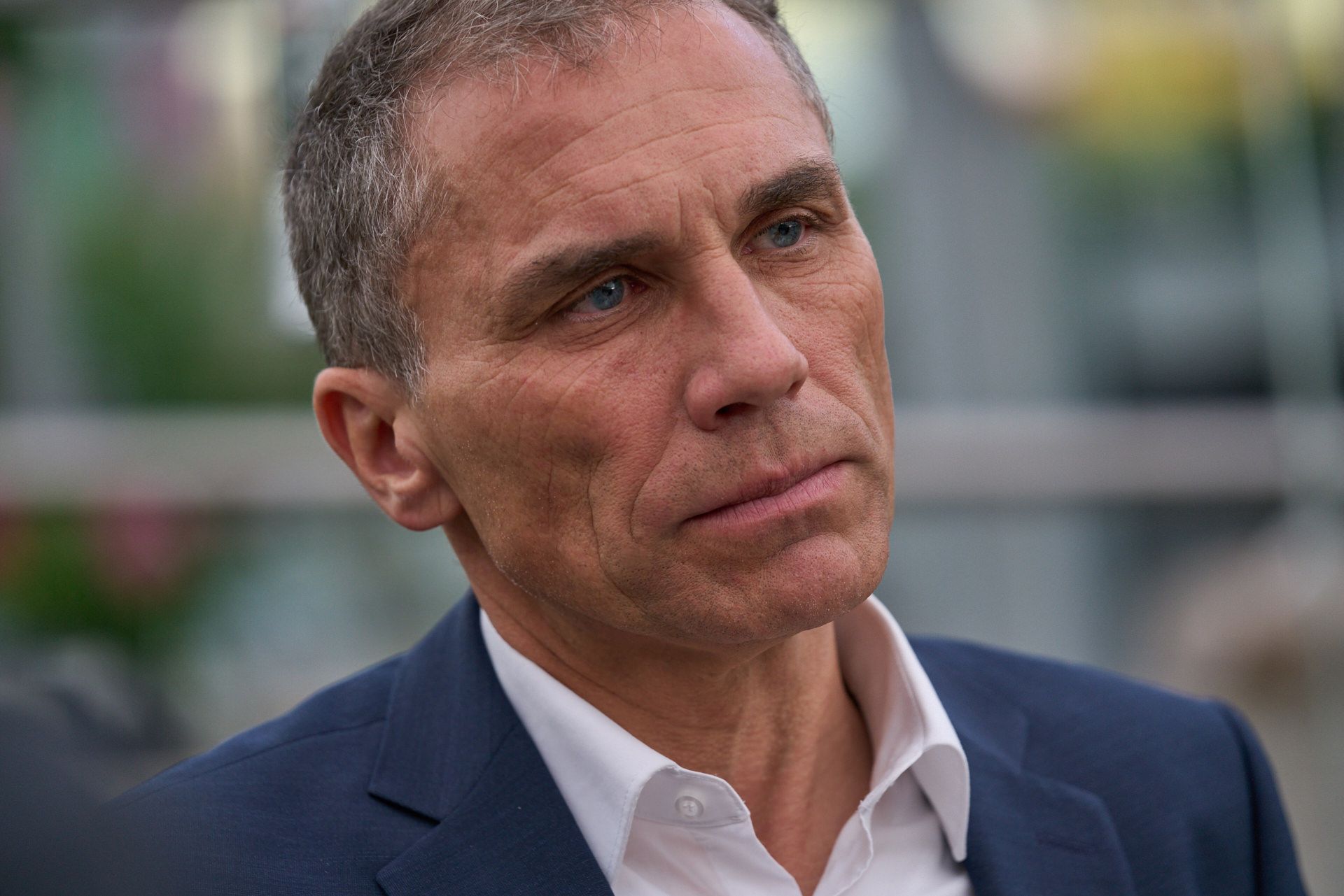 Ein Mann in Anzug und weißem Hemd schaut in die Kamera.