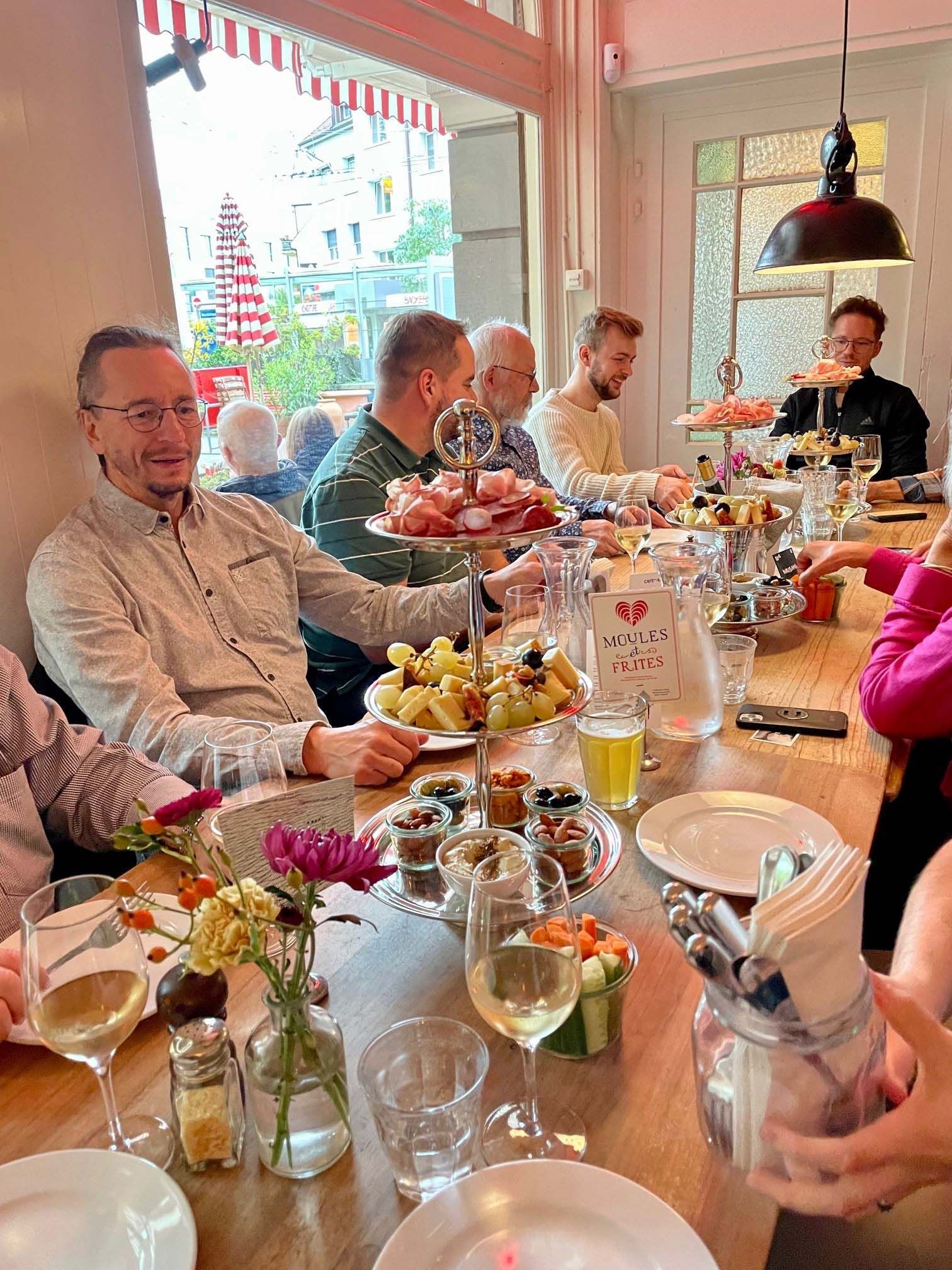 Eine Gruppe Leute sitzt an einem Tisch und isst.