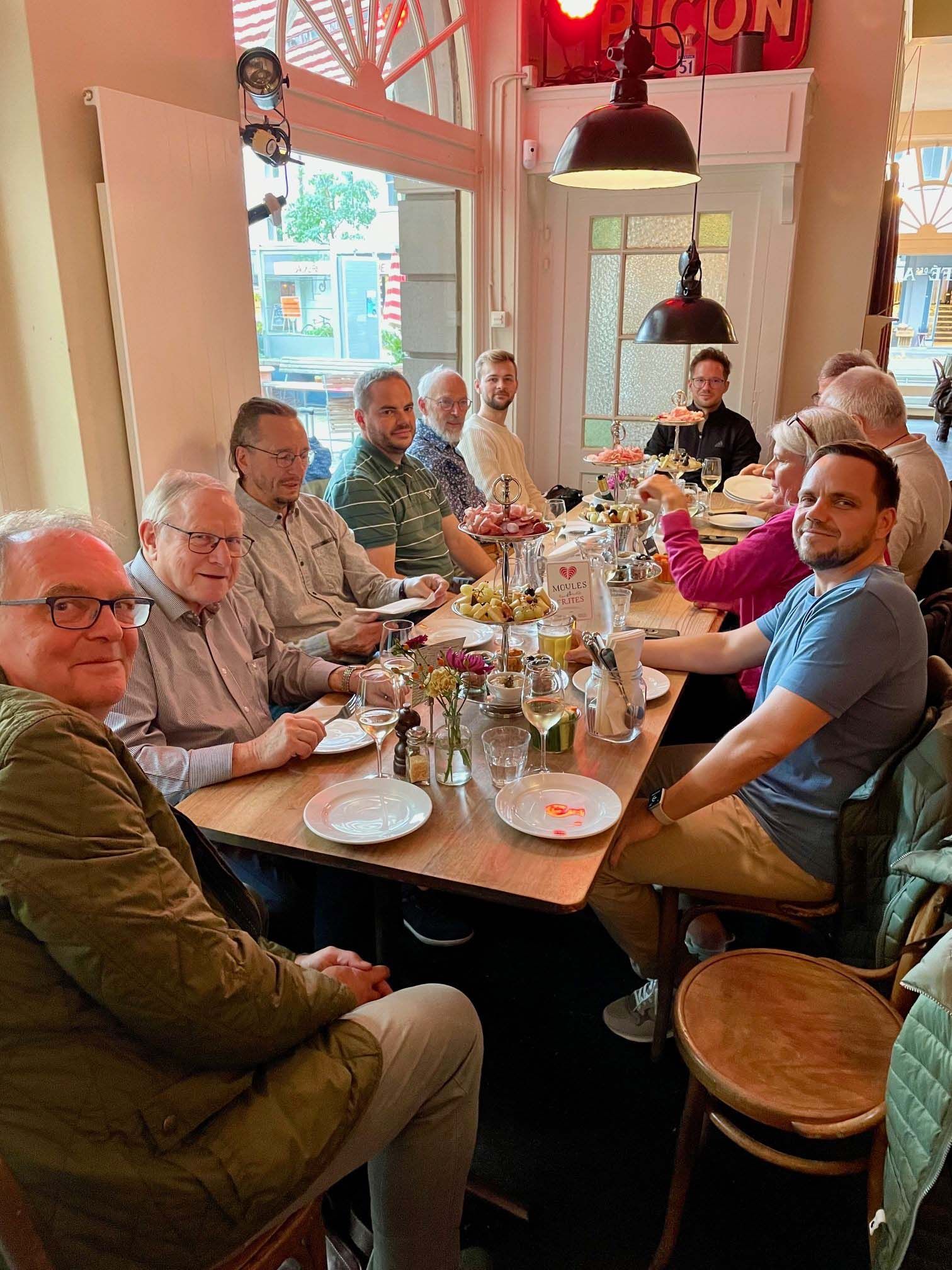 Eine Gruppe von Menschen sitzt in einem Restaurant an einem langen Tisch.