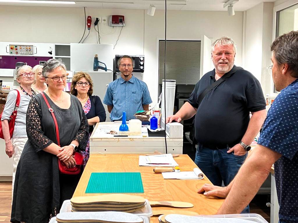 Eine Gruppe von Leuten steht in einer Küche um einen Tisch herum.