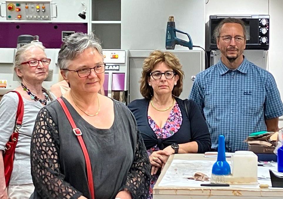 Eine Gruppe von Menschen steht nebeneinander in einem Raum.