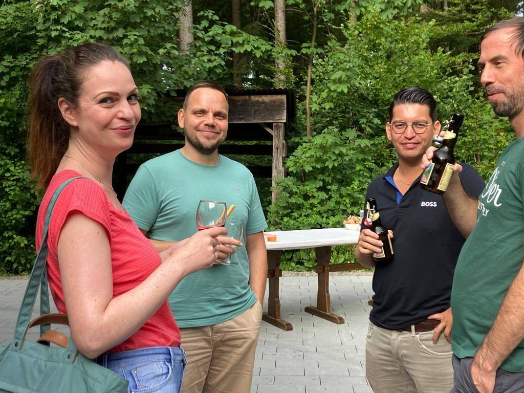 Eine Gruppe von Leuten steht nebeneinander und hält Bierflaschen in den Händen.