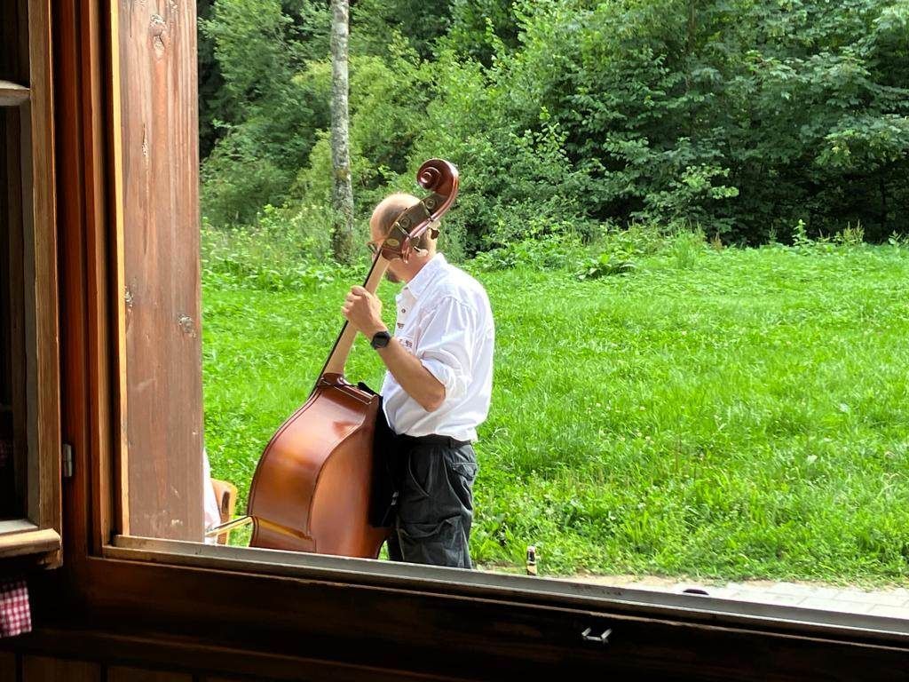 Ein Mann spielt vor einem Fenster Kontrabass.