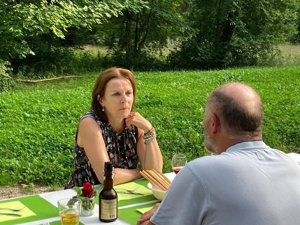 Ein Mann und eine Frau sitzen mit einer Flasche Bier an einem Tisch.