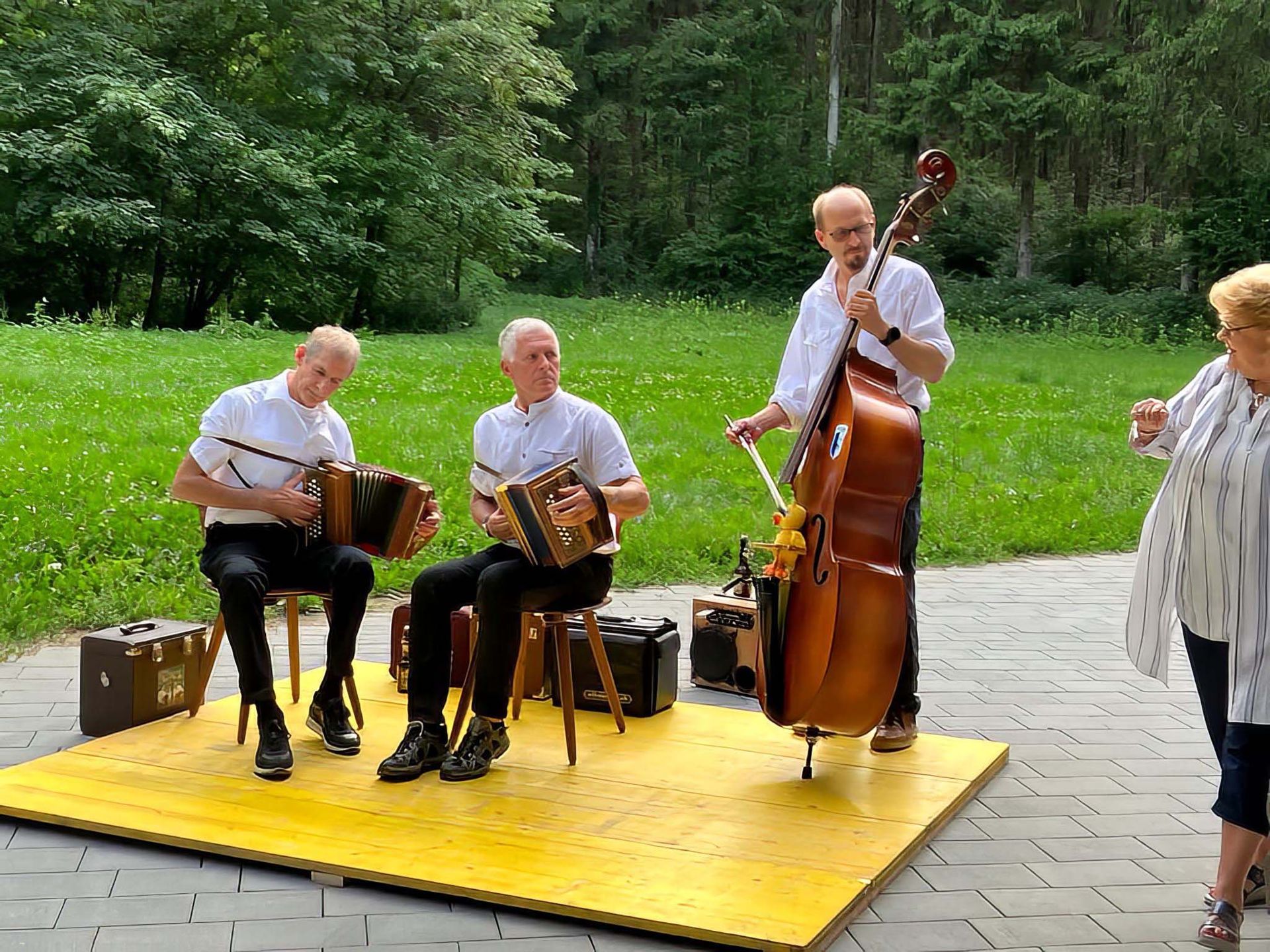 Eine Gruppe Männer spielt in einem Park Musikinstrumente.