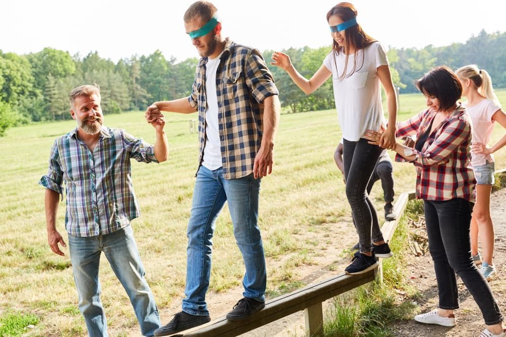 A Group of People Are Standing on a Wooden Balance Beam — Empowering You Disability Services In Maryborough, QLD