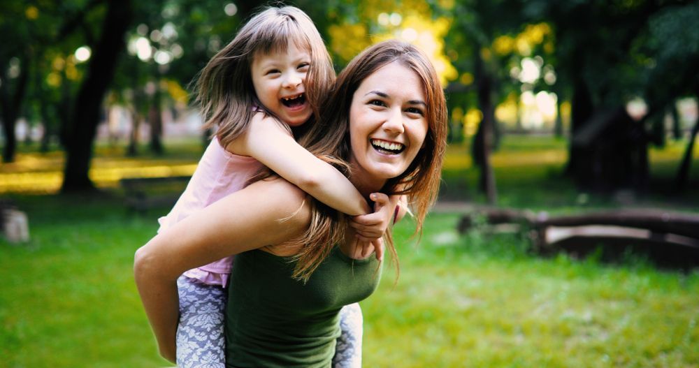 Woman Holding a Young Girl Smiling — Empowering You Disability Services In Maryborough, QLD