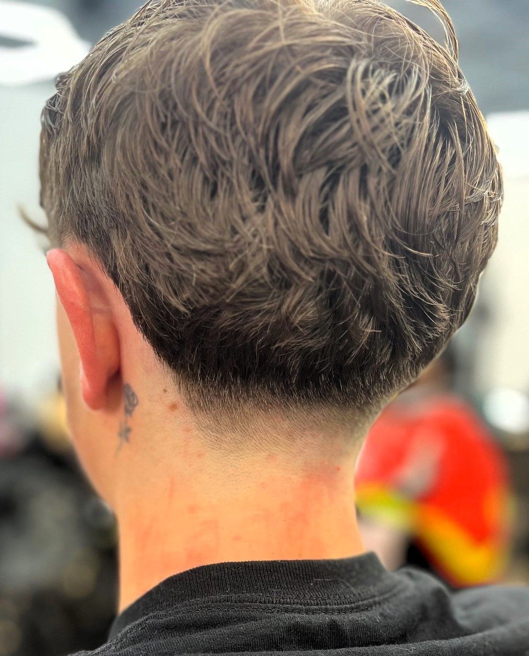 Man with a faded nape and textured brown hair. Back view.