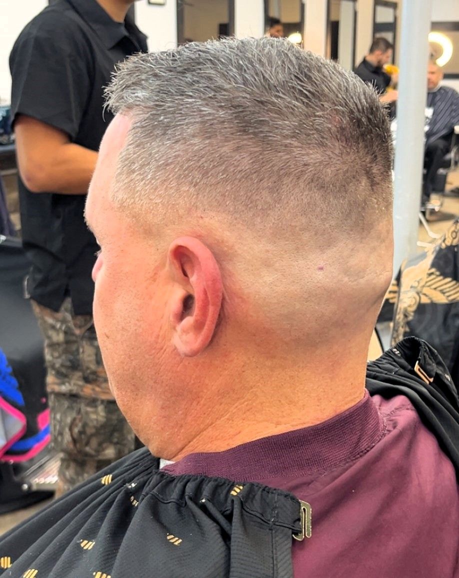 Man with a short, faded haircut, in a barbershop setting.